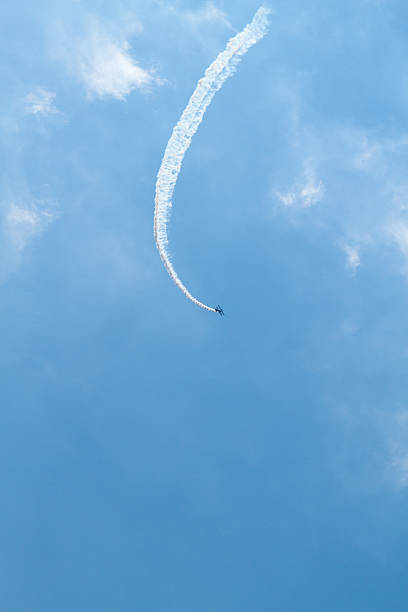 mały odległy dwupłat z dymu trail. - stunt stunt plane airplane small zdjęcia i obrazy z banku zdjęć