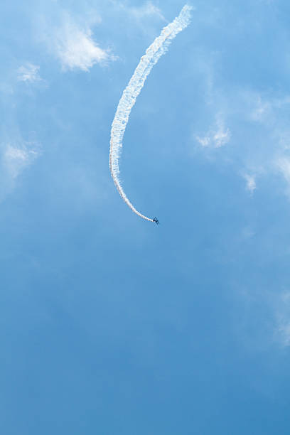 pequeno avião biplano distantes com fumaça trail. - stunt stunt plane airplane small - fotografias e filmes do acervo