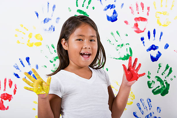 istock Young Hispanic Asian girl playing with finger paints 183372131