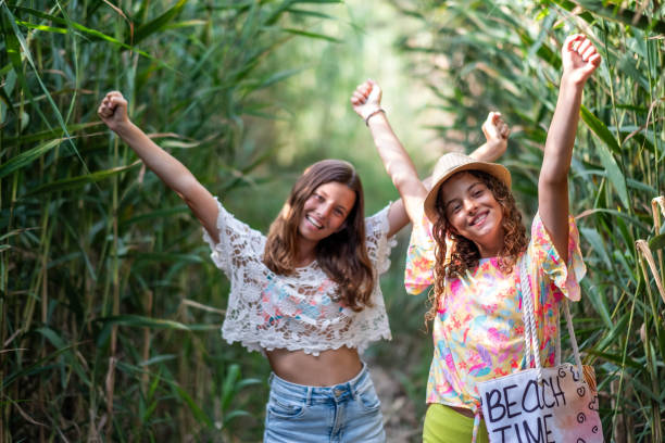 Two little girls are walking through a narrow path and they are happy
