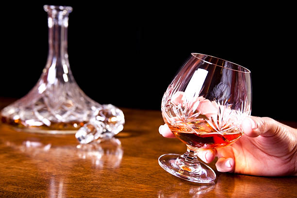 istock Single woman with brandy glass, decanter in background 183372193