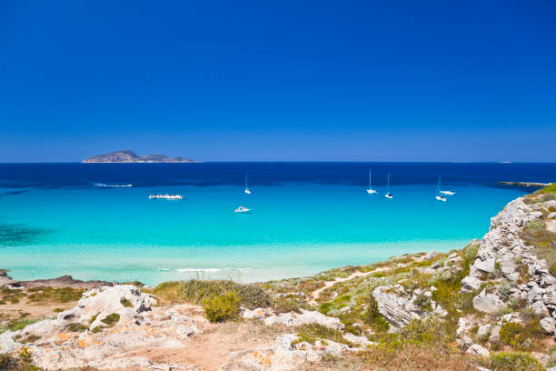 Stunning Mediterranean beach view with several sailing boats "Mediterranean beach - photo taken on Favignana Island, Sicily, Italy.See also:" egadi islands photos stock pictures, royalty-free photos & images