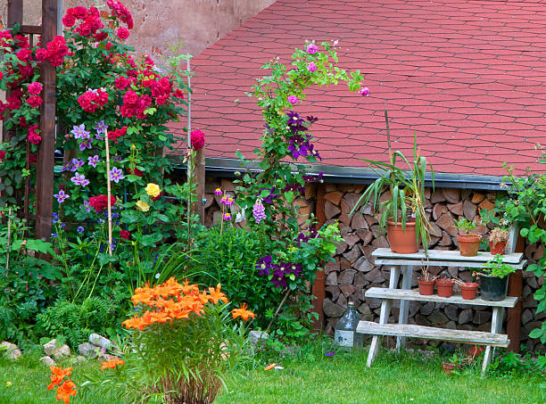 colorful flowers in a backyard with roof and wood billets