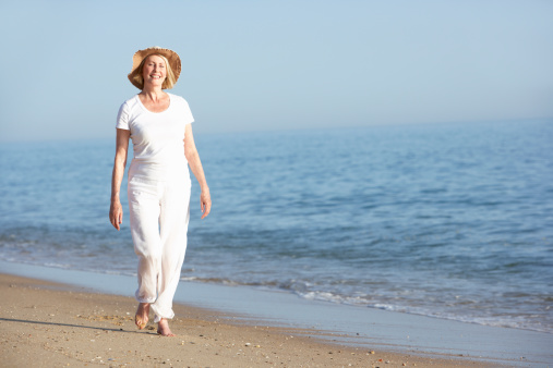 Happy woman enjoying while walking during summer vacation on the beach. Copy space.