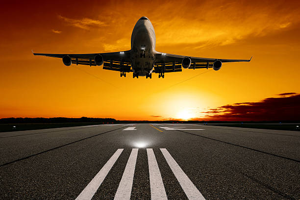 istock XL jumbo jet airplane landing at sunset 183374406