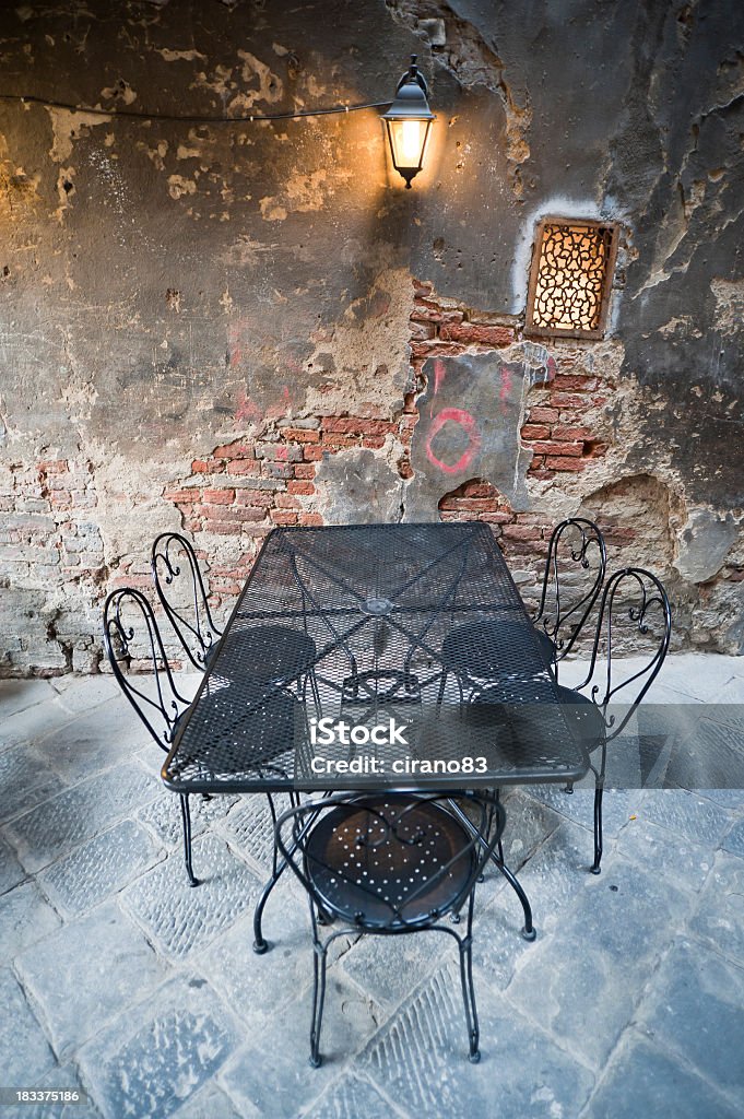 Rustico angolo con tavolo e lampada In città di Siena, Toscana. - Foto stock royalty-free di Caffè all'aperto