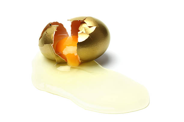istock Yolk Caming Out from a Broken Golden Egg 183375454