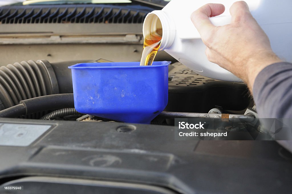 Filling oil on truck engine Filling diesel truck engine with motor oil using funnelMore optionsaA| Car Stock Photo