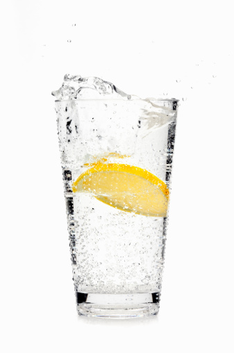 Lemon slice splashing into soda water.Please visit my