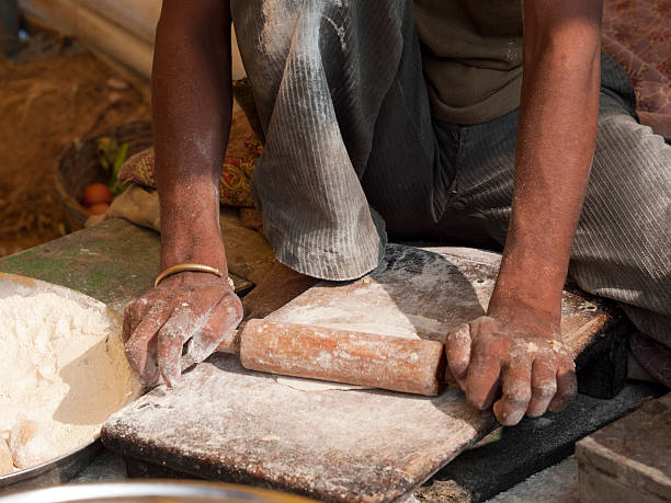 istock Man rolling Chappatis at a food stand in India 183376094