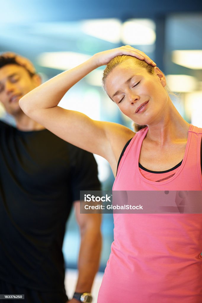 Женщина, растяжения ее шеи в тренажерный зал - Стоковые фото 20-29 лет роялти-фри