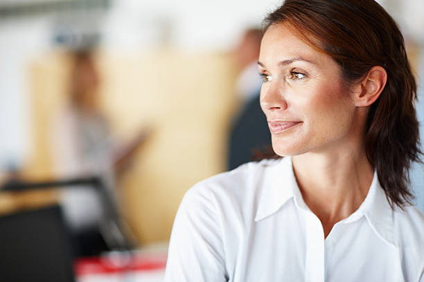 ritratto di donna di pensiero con i colleghi in background - defocused business women occupation foto e immagini stock