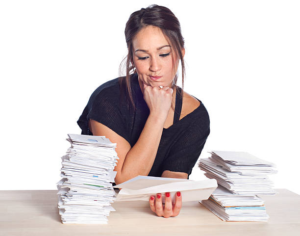 istock Financial Problems, Young Woman with Unpaid Bills and Paperwork Overload 183376632