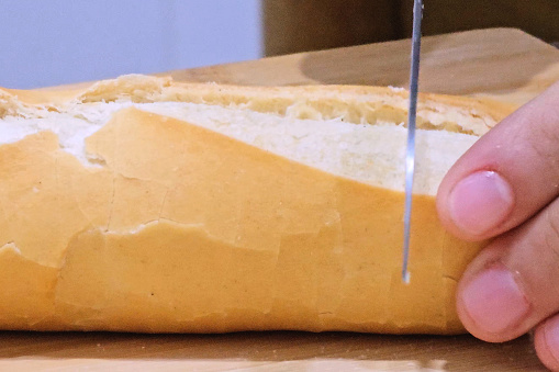 Brown bread slices (can be black wheat, or oat), with bread knife on the wooden plank as background; Adobe rgb color space