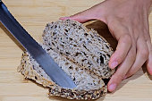 Cutting a slice of whole grain bread