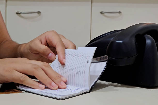 istock Young woman looking for a phone in the notebook 1833768500