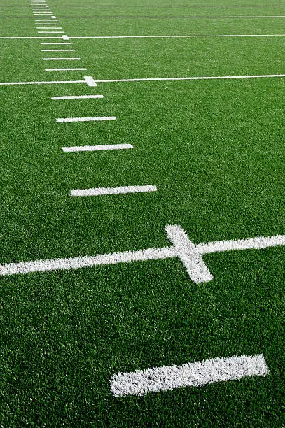 Grass on a football sports field with the white hash marks.
