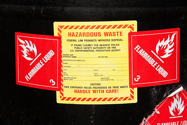 Close-up of the haradous waste label and flammable labels on a barrel of industrial chemicals.