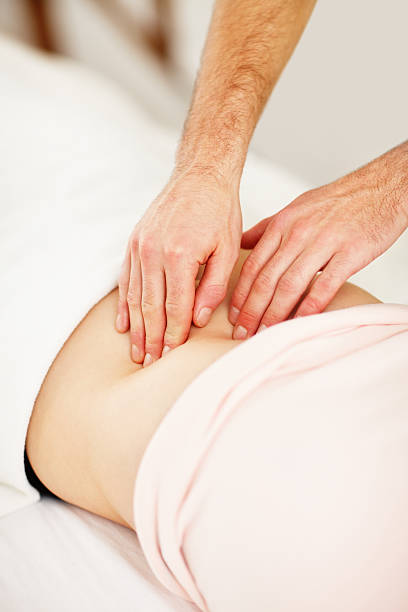 istock Masseur massaging woman's abdomen 183376937