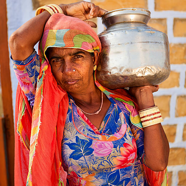 istock Indian woman carrying water from well 183377438