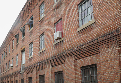 Grim view of a drab apartment row over an empty lot on a gray day