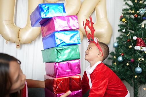 Merry Christmas 2024 concept Boy receives a gift from his mother at christmas