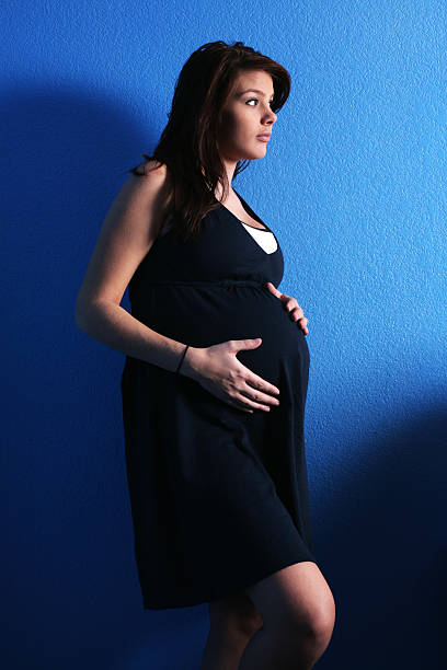 Baby Blue Too "Beautiful young pregnant woman, against a blue wall." too thin stock pictures, royalty-free photos & images