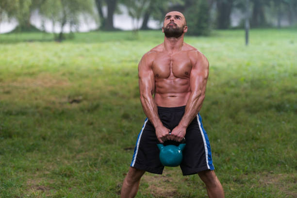 istock Attractive Male Athlete Performing A Kettle-Bell Swing 1833785247