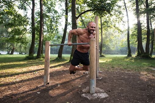 Young Athlete Working Out Triceps In An Outdoor Gym - Doing Street Workout Exercises