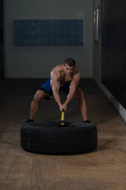 istock Workout At Gym With Hammer And Tractor Tire 1833787443