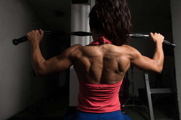 Fitness Woman Doing Exercise For Back On Machine stock photo