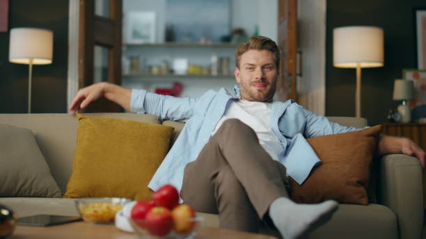 istock Carefree gentleman sitting evening home. Positive guy taking tablet computer 1833798446