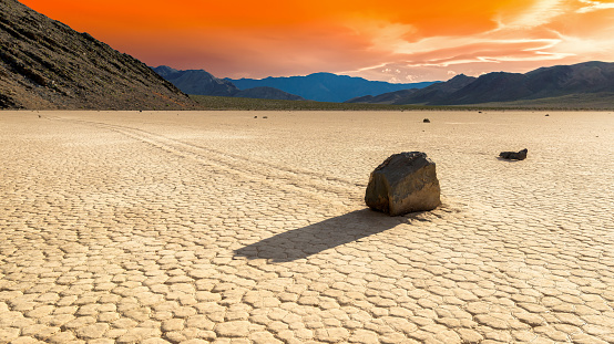Moving stones in Racetrack Playa at sunset in Death Valley National Park, California