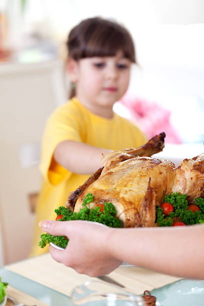 istock Woman setting the table, serving roast chicken for Christmas dinner 183380680
