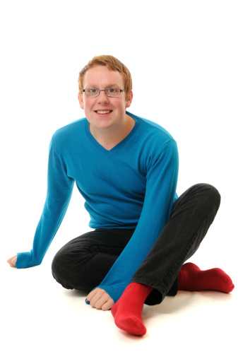 A happy young man sitting down. XL image size.