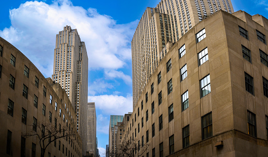 New York City skyline, skyscrapers, buildings with white clouds on the blue sky backgrounds, wide low angle diminishing perspective view