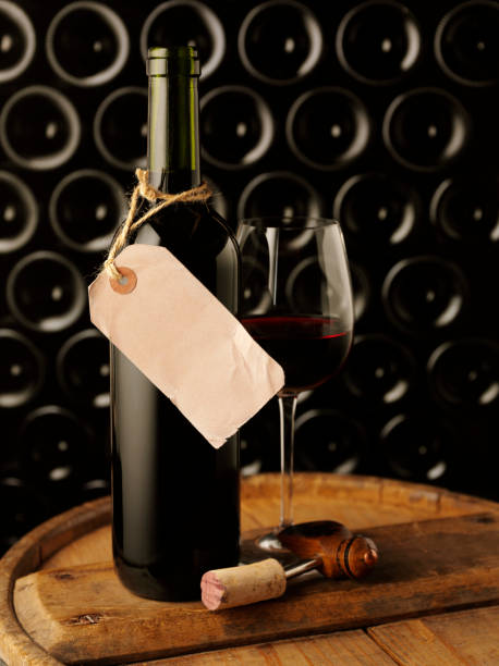 Wine bottle with a glass of red wine with a wine bottle background and copy space on a old label.