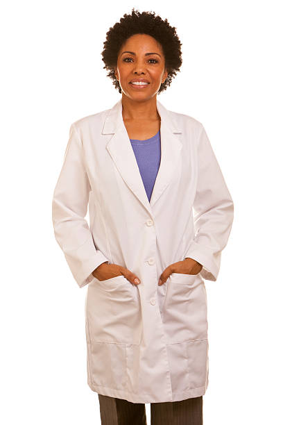 African ethnicity female wearing lapcoat with hands in pockets "African ethnicity female doctor wearing lab coat, isolated on white background" african american scientist stock pictures, royalty-free photos & images