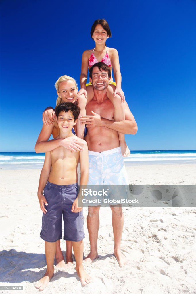 Famiglia sorridente felice affettuoso sulla spiaggia - Foto stock royalty-free di Abbigliamento casual