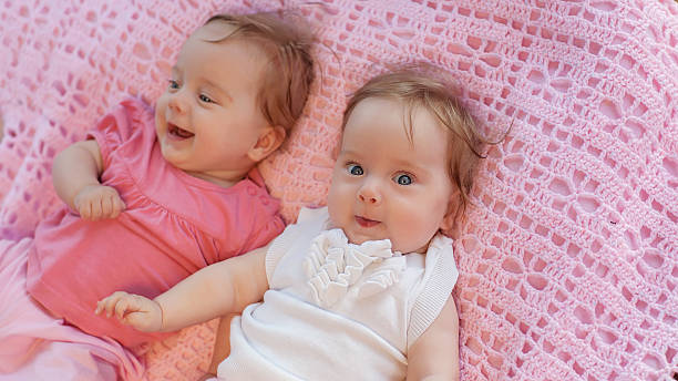 istock Sweet little  twins lying on a pink blanket. 183383008