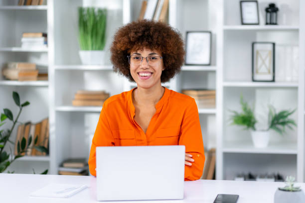istock Stylish Female Working on Laptop Computer in a Company Office look at camera. 1833830963