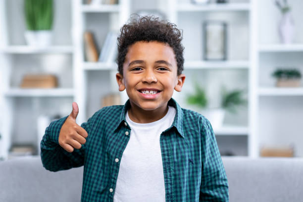 istock cheerful happy young small boy make finger thumb up smile recommend 1833831495