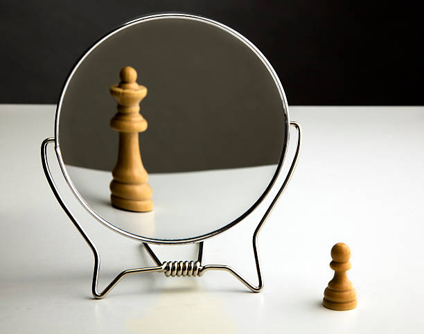 Chess Pawn Imagining Itself as a Queen. Lowly Chess Pawn standing in front of mirror envisioning itself as a Queen. pawn chess piece photos stock pictures, royalty-free photos & images