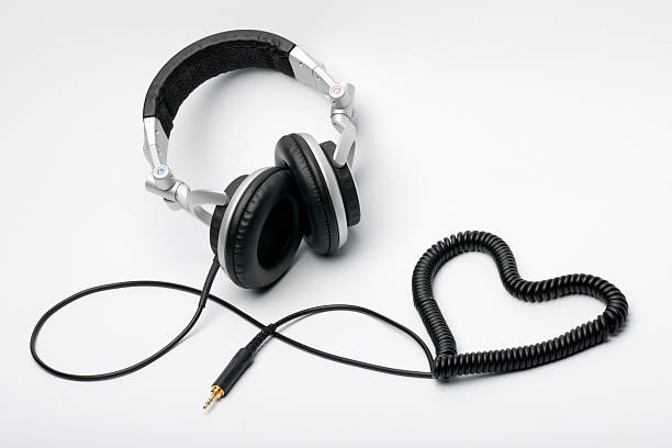 Love for Music - Headphones Heart (XXXL) Headphones with a heart shaped cord lying on a white canvas. Nikon D3X. Converted from RAW. headphones plugged in photos stock pictures, royalty-free photos & images