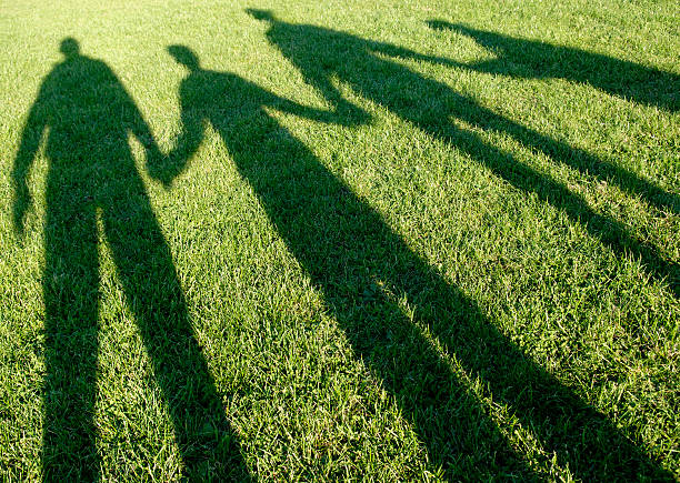 Family of four shadows in the park stock photo
