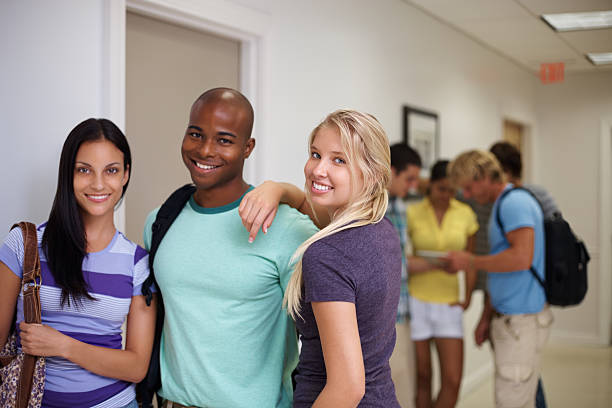 istock College friends standing together with classmates in background 183384262