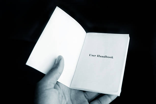istock hand holding user handbook guide in monochrome 183384317