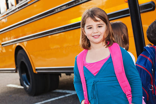 istock Young Girl Standing in Line at School Bus 183384680