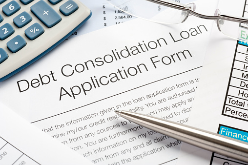 Close up of Debt Consolidation Loan Application Form with pen, calculator
