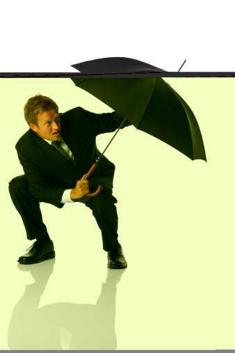 Businessman crouched down shielding himself with an umbrellahttp://www.twodozendesign.info/i/1.png